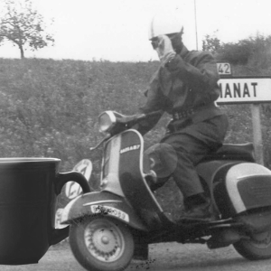 man riding motor cycle with coffee mug